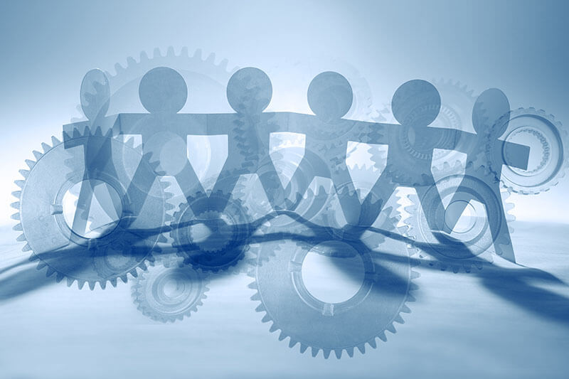 Mitarbeiterbindung Symbolbild Papiermännchen und Zahnräder