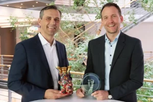 Geschäftsführer Karsten Marquardsen (links) und Finn Hassold, Leiter Produktmanagement Digital, halten die Auszeichnungen in den Händen.